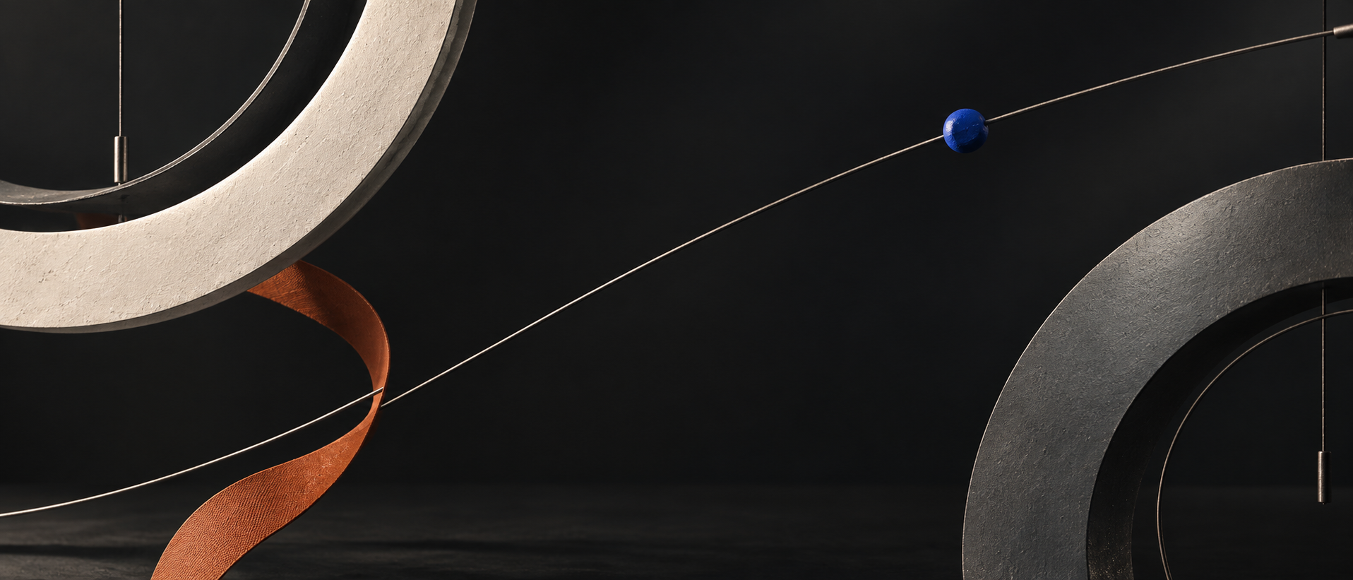 Signal study still: stone and copper rings with a cobalt sphere. Campaign image, not a product photograph.